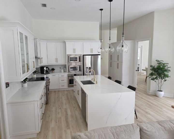 contemporary-kitchen-refurbishment-sarasota-fl-720x576px Modern white kitchen with island and pendant lights.