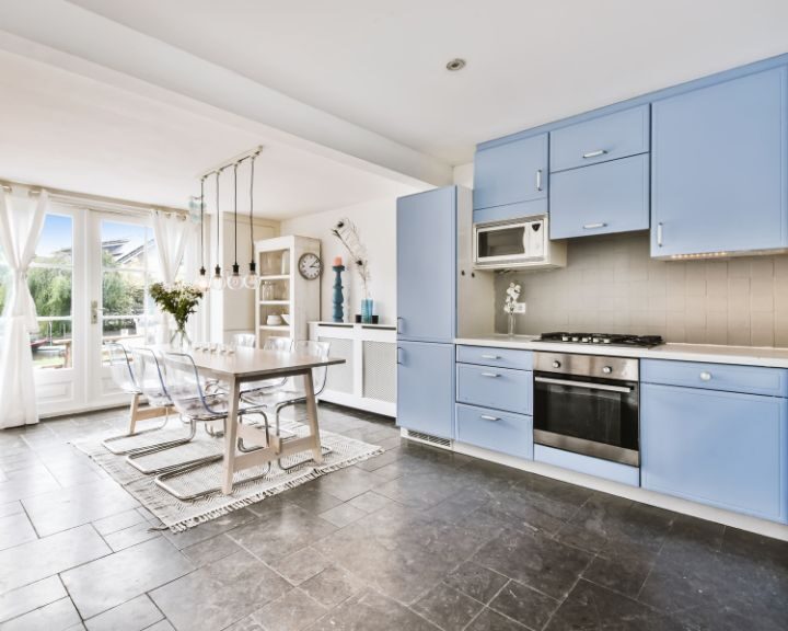 a kitchen with blue cabinets and a white table.