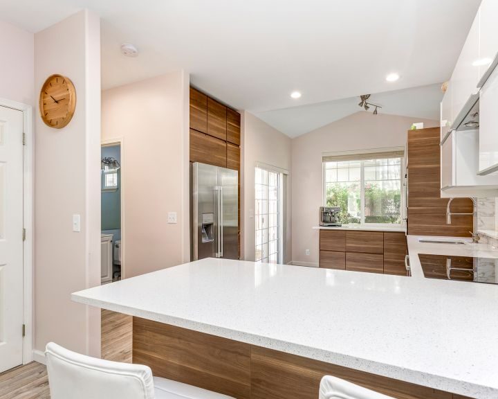 a kitchen with an island and a clock on the wall.