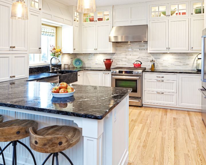 a large kitchen with a center island with a bowl of fruit on it.