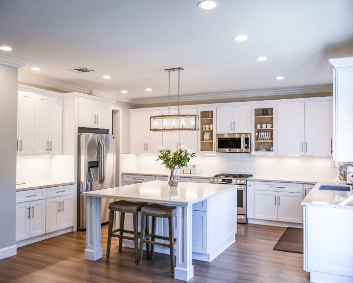 a large kitchen with a center island and white cabinets.