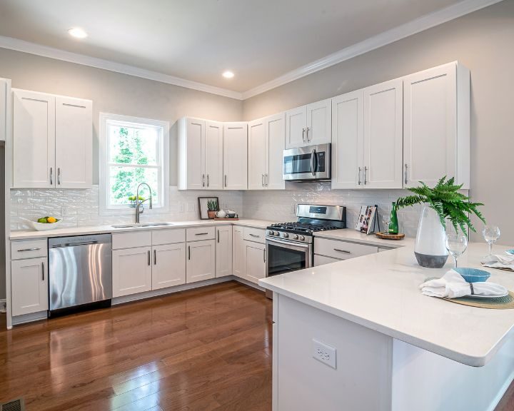 a kitchen with white cabinets and stainless steel appliances.