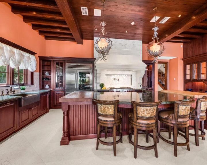 kitchen-remodeling-sarasota-fl-720x576px Luxurious kitchen with wooden cabinets and bar stools.