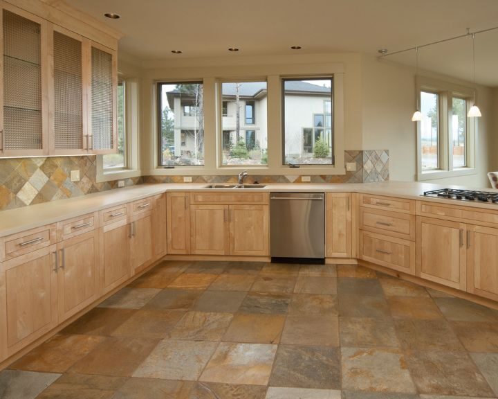 a kitchen with a tile floor and wooden cabinets.